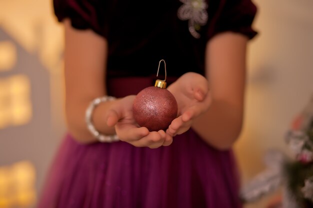 Mulher segurando uma bola de brinquedo grande de decoração de natal