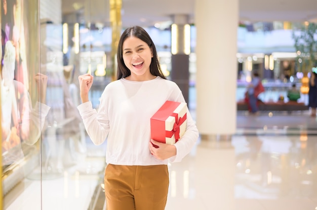 Mulher segurando uma caixa de presente em um shopping