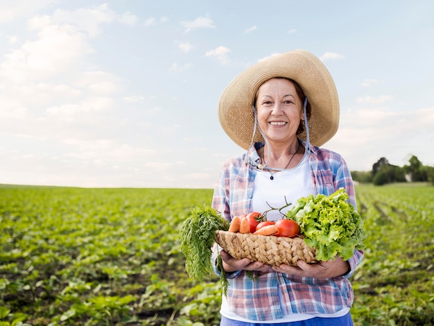 Foto mulher segurando uma cesta cheia de legumes