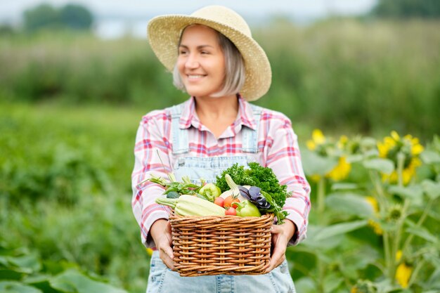 Mulher segurando uma cesta cheia de vegetais orgânicos de colheita e raiz na fazenda orgânica Bio. Colheita De Vegetais De Outono.