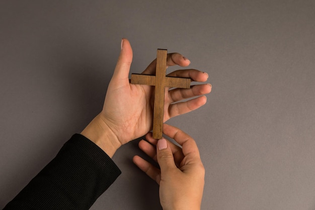 Mulher segurando uma cruz de madeira na mão