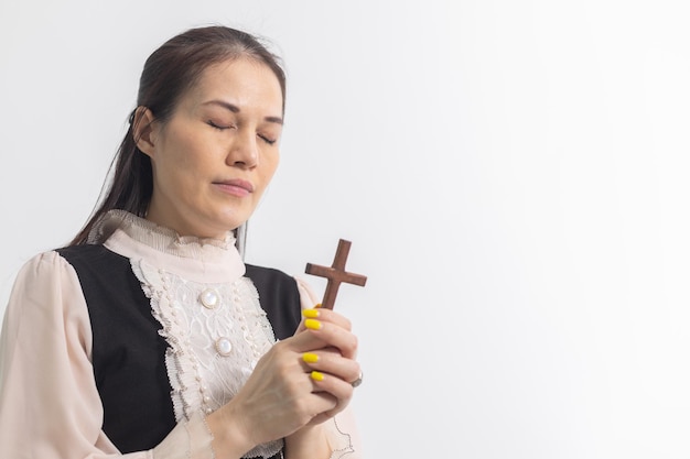 Mulher segurando uma cruz de madeira orando por deus religião