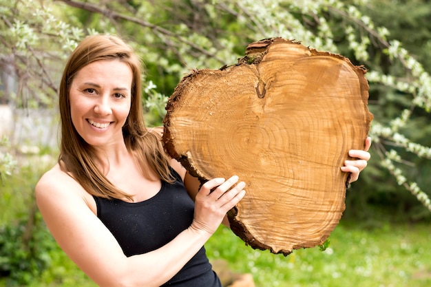 Mulher segurando uma fatia de madeira log