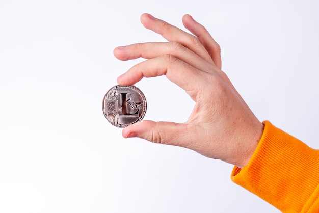 Mulher segurando uma moeda física de Litecoin (LTC). Conceitos de criptomoeda em fundo branco.