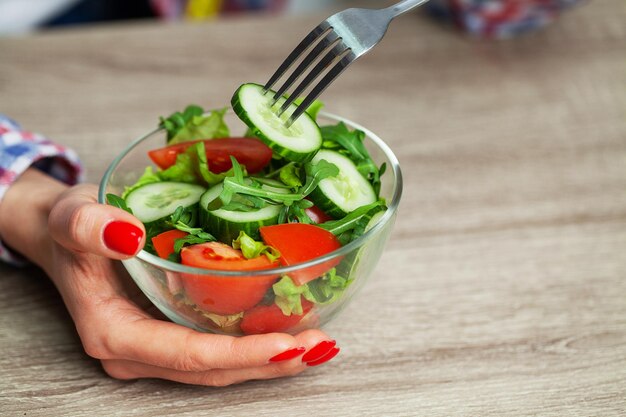 Mulher segurando uma salada nas mãos para um estilo de vida saudável.