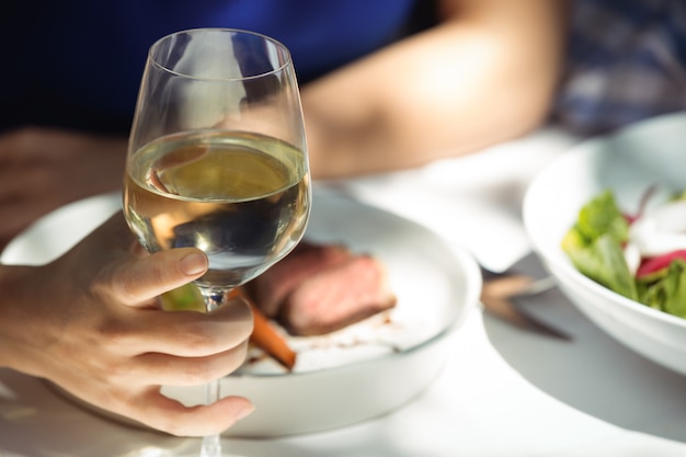 Mulher segurando uma taça de vinho no restaurante