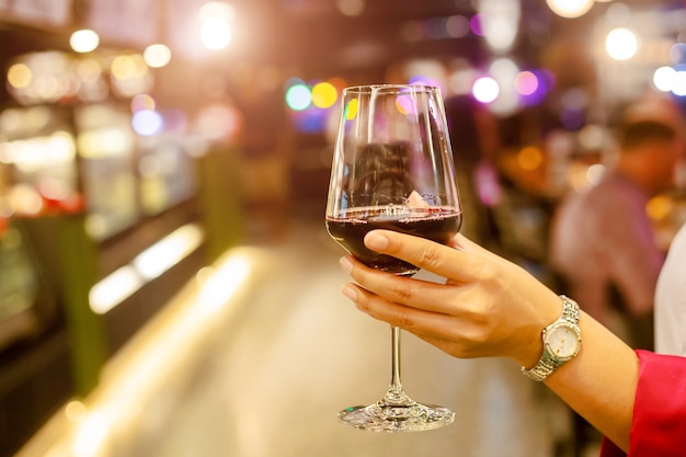 Mulher segurando uma taça de vinho no restaurante