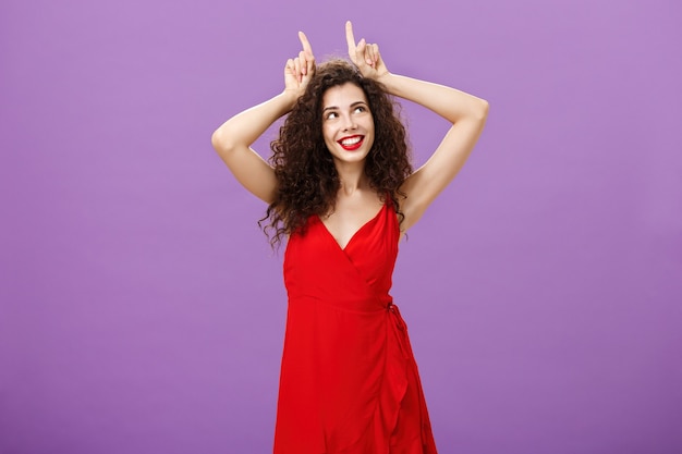 Mulher sendo audaciosa na festa sensual e sedutora em um vestido de noite vermelho elegante segurando ...