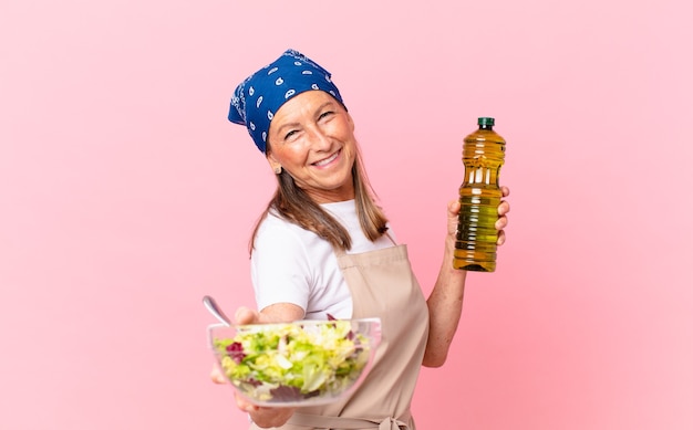 Mulher sênior bonita preparando uma salada