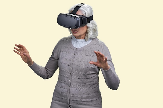 Mulher sênior com fone de ouvido de realidade virtual está atordoada com a experiência vr velha usando óculos vr o