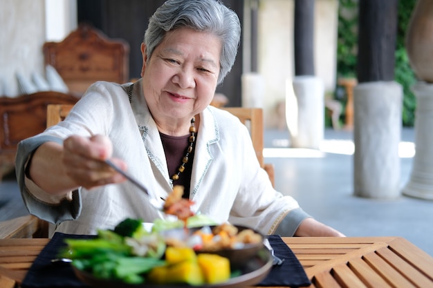 Mulher sênior, comer comida