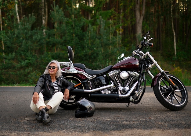 Mulher sênior de tiro completo com motocicleta