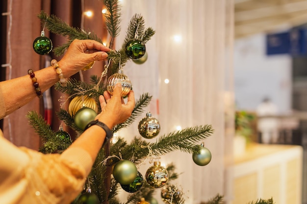 Mulher sênior decorando uma árvore de natal em casa