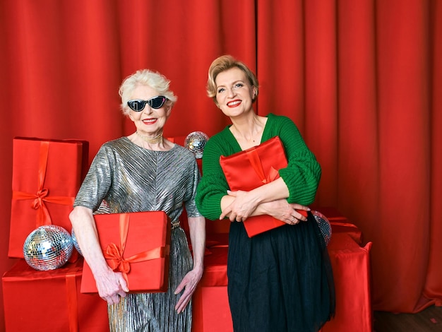 Mulher sênior e madura elegante e chique na festa com caixas de presente. festa, celebração