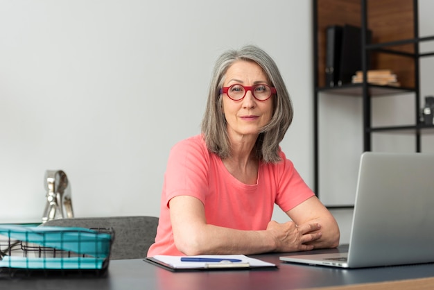 Foto mulher sênior em casa estudando no laptop