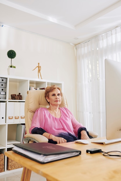 Mulher sênior em sua mesa de escritório