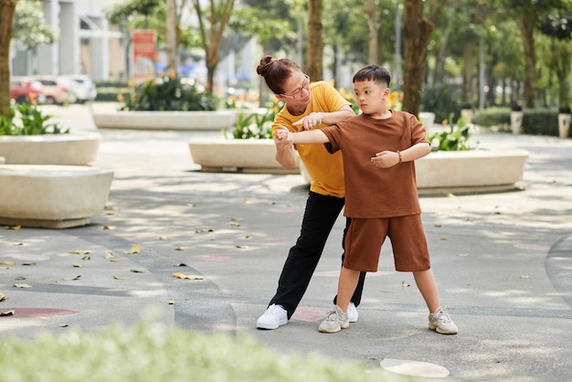 Mulher sênior ensinando exercícios para meninos