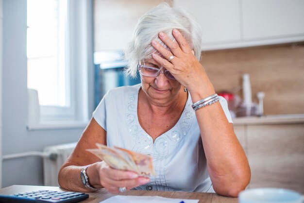 Mulher sênior estressada está fazendo trabalho bancário e administrativo em casa