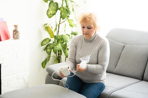 Mulher sênior fazendo inalação, mulher idosa e nebulizador.