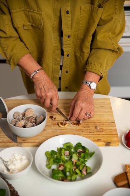 Foto mulher sênior fazendo prato com figos na cozinha