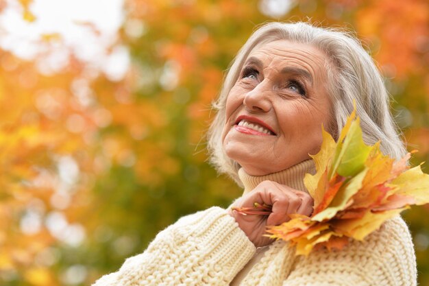 Mulher sênior feliz sorrindo e posando no parque outono