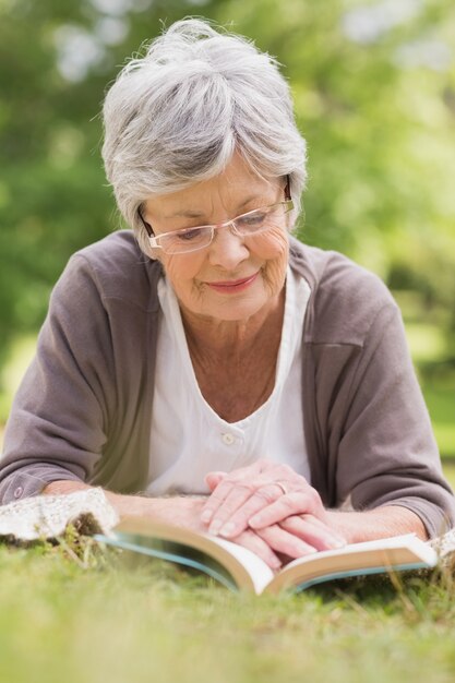 Mulher sênior lendo um livro no parque