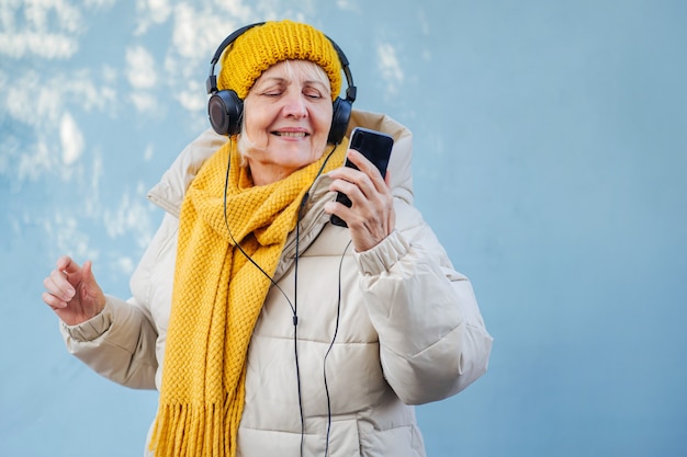 Mulher sênior, ouvindo música e usando o smartphone.