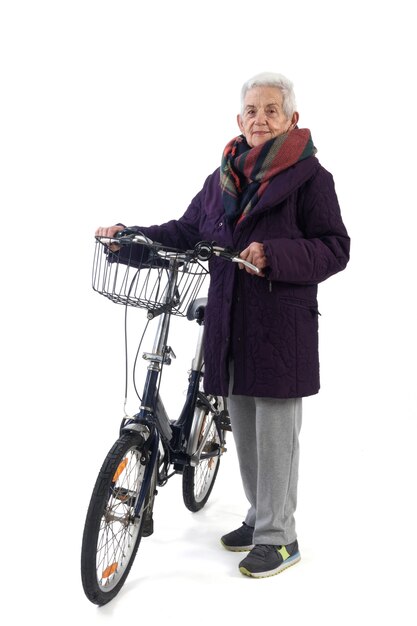 Mulher sênior posando com uma bicicleta no fundo branco