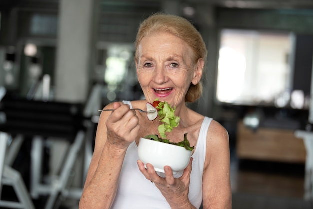 Foto mulher sênior que come a salada saudável. conceito de estilo de vida de saúde idosos.