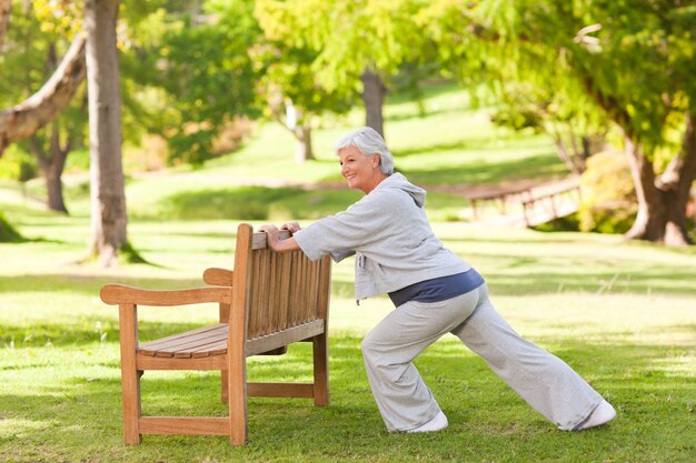 Mulher sênior que faz seus trechos no parque