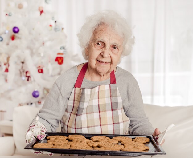 Mulher sênior, segurando, assado, biscoitos