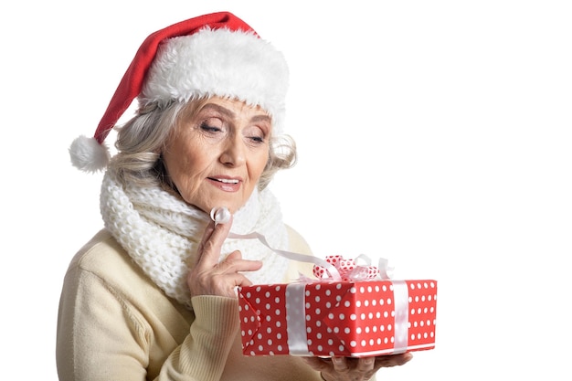 Mulher sênior sorridente com chapéu de Papai Noel posando com presente isolado no fundo branco