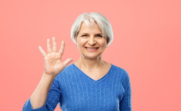 mulher sênior sorridente mostrando palma ou cinco dedos