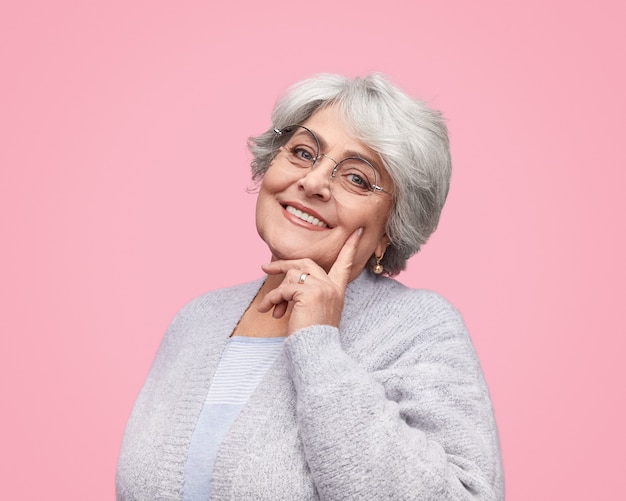 Mulher sênior sorridente tocando a bochecha