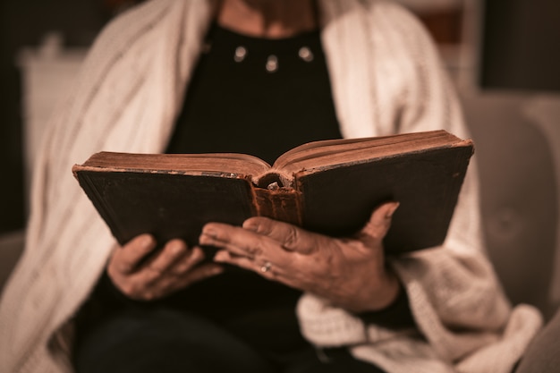 Mulher sênior tem um livro antigo nas mãos