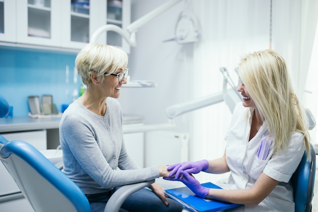 Mulher sênior, tendo tratamento dentário no consultório do dentista.