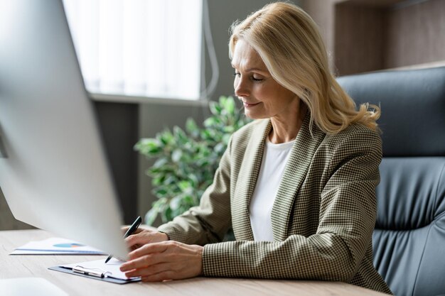 Mulher sênior trabalhando em conceitos online de pc sobre negócios e tecnologia