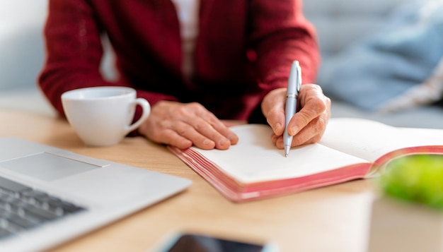 Mulher sênior trabalhando em home office. As mãos fecham.