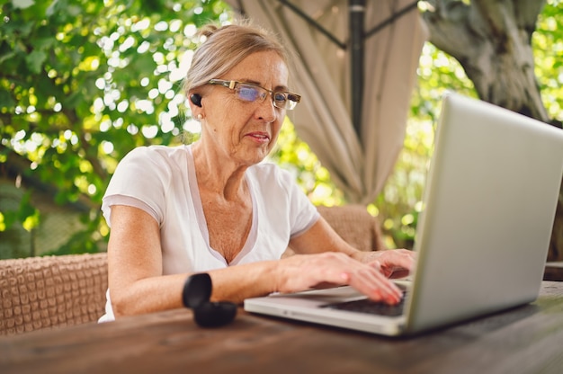 Mulher sênior trabalhando online com laptop