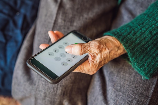 Mulher sênior usando telefone celular enquanto está sentado no sofá