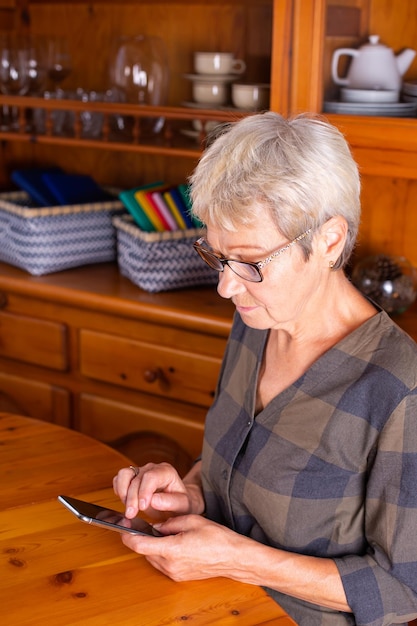 Mulher sênior usando telefone fazendo videochamada