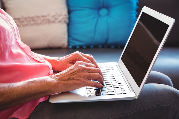 Mulher sênior, usando um laptop