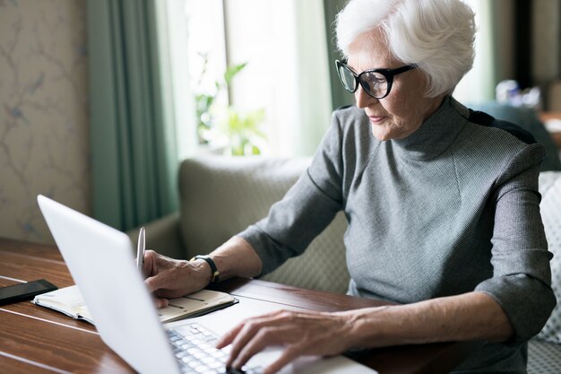 Mulher sênior, usando um laptop