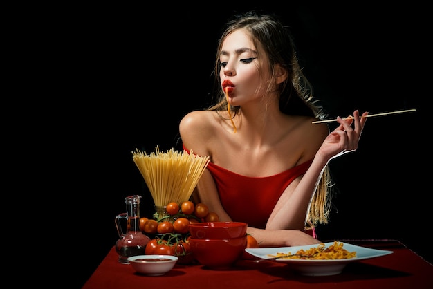 Mulher sensual come espaguete. Conceito de comida saudável. Fome e apetite. Menina surpresa com macarrão espaguete. Macarrão de massa longa.