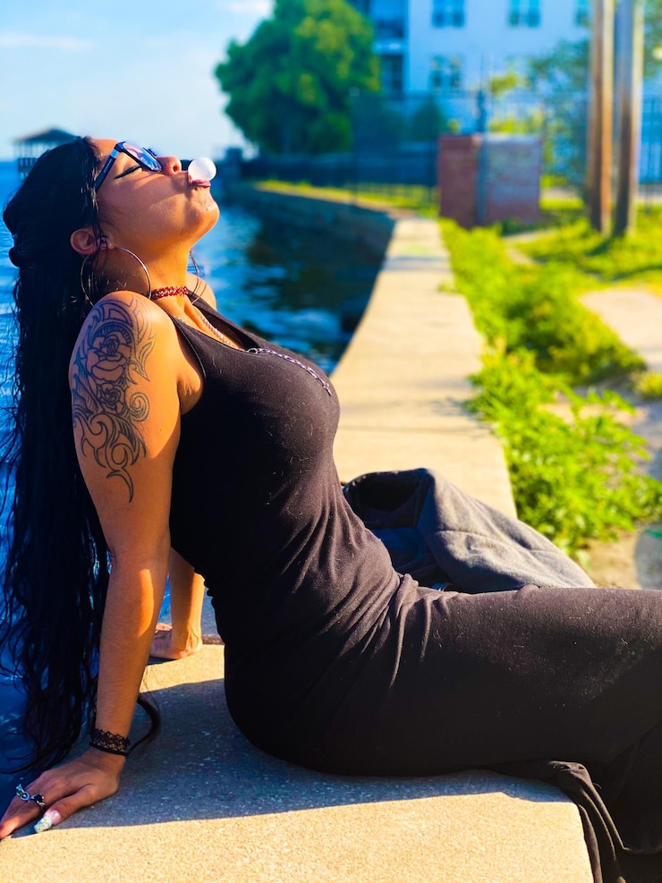 Foto mulher sentada à beira da água