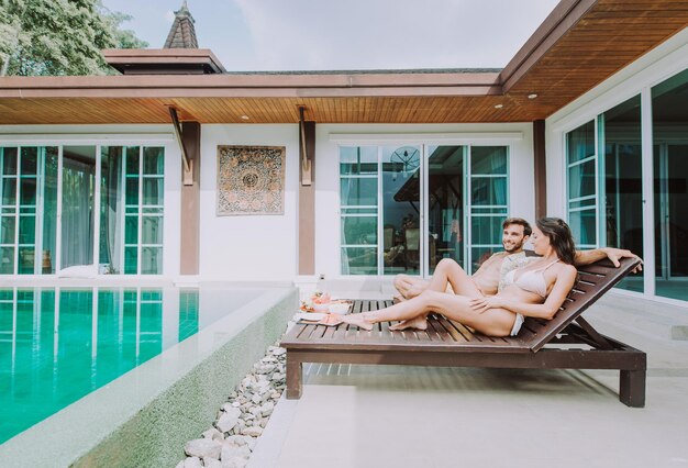 Foto mulher sentada à beira da piscina