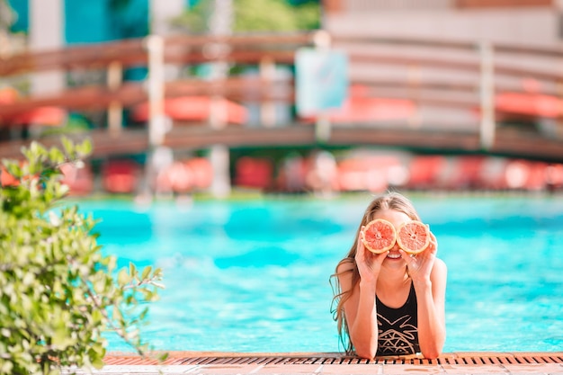 Foto mulher sentada à beira da piscina