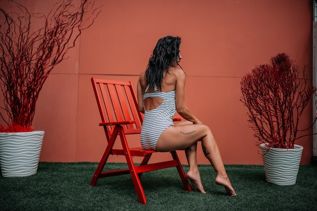 Mulher sentada em uma cadeira contra plantas