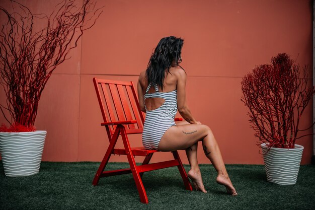 Mulher sentada em uma cadeira contra plantas