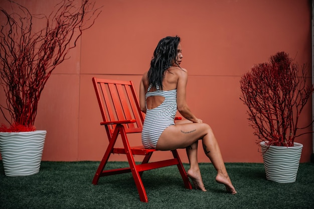 Mulher sentada em uma cadeira contra plantas